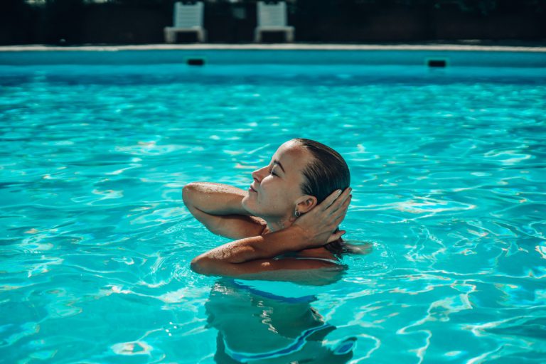 A,Woman,Is,Swimming,In,A,Pool.,She,Is,Smiling