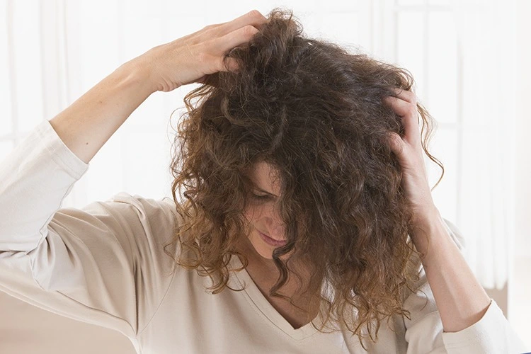 Femme qui se gratte les cheveux